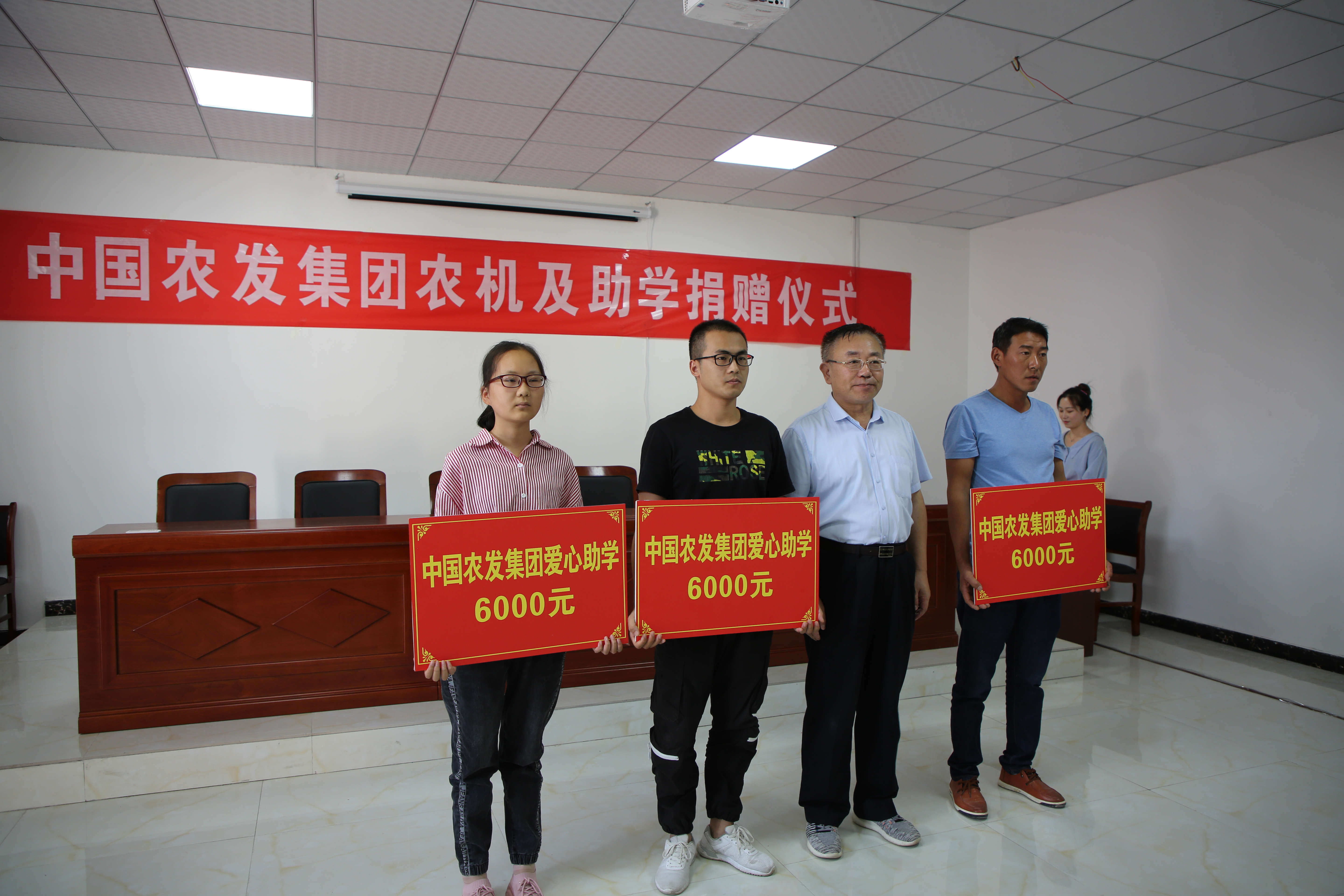 附件1  万军（右二）向今年新考取大学的贫困家庭子女每人捐赠6000元爱心助学金.jpg